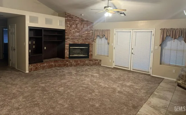 an empty room with windows and fireplace