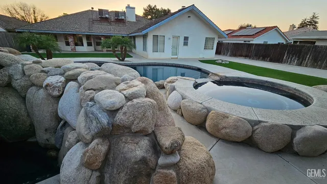 a room with water heater and wooden cabinets