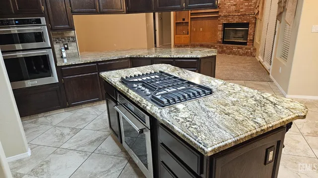 a kitchen with stainless steel appliances granite countertop a stove a sink and a microwave