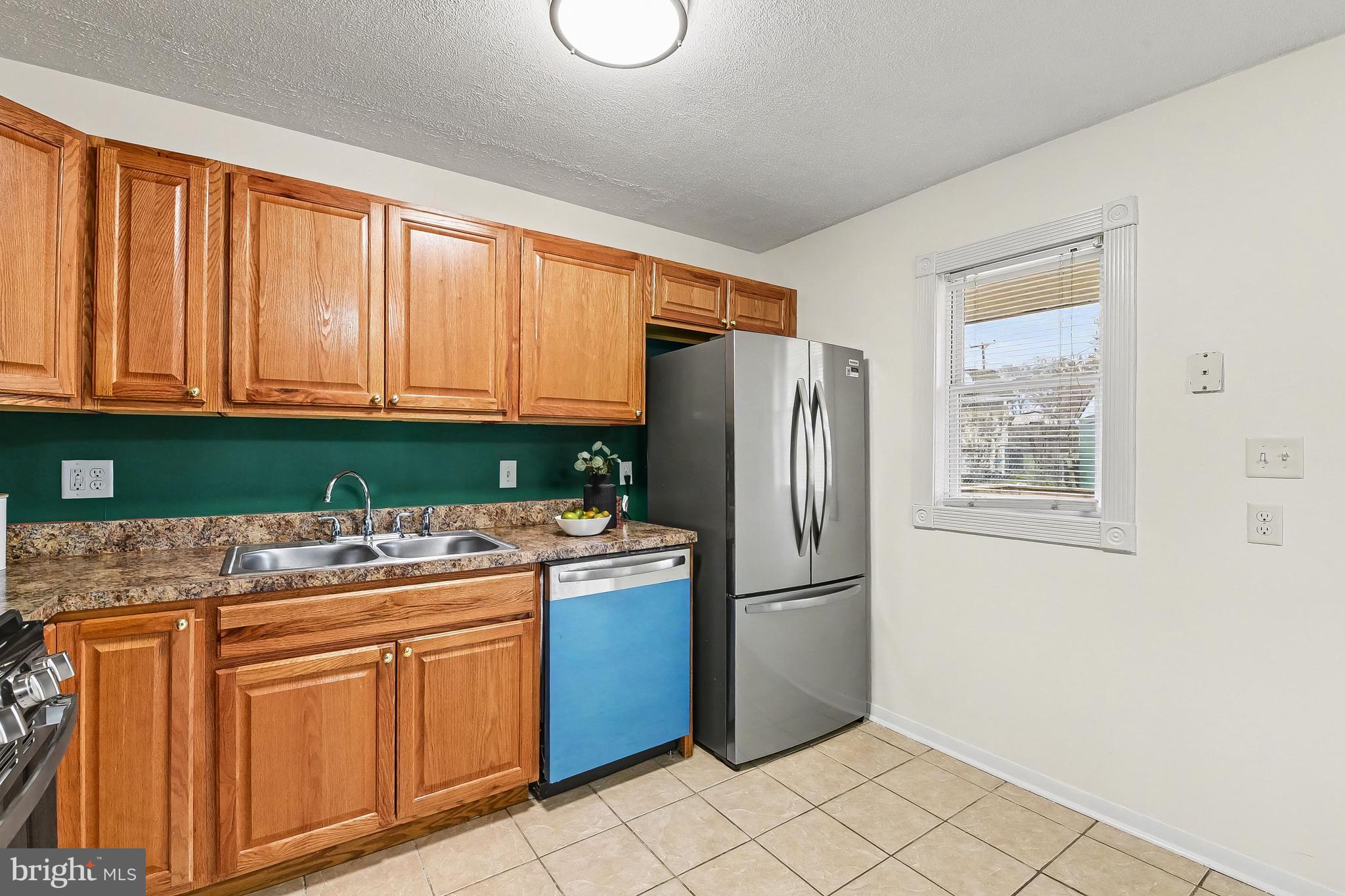 2309 Perry Avenue Edgewood, MD 21040 - Photo 10 of 25 a kitchen with stainless steel appliances granite countertop a refrigerator a sink a stove a washer dryer and white cabinets