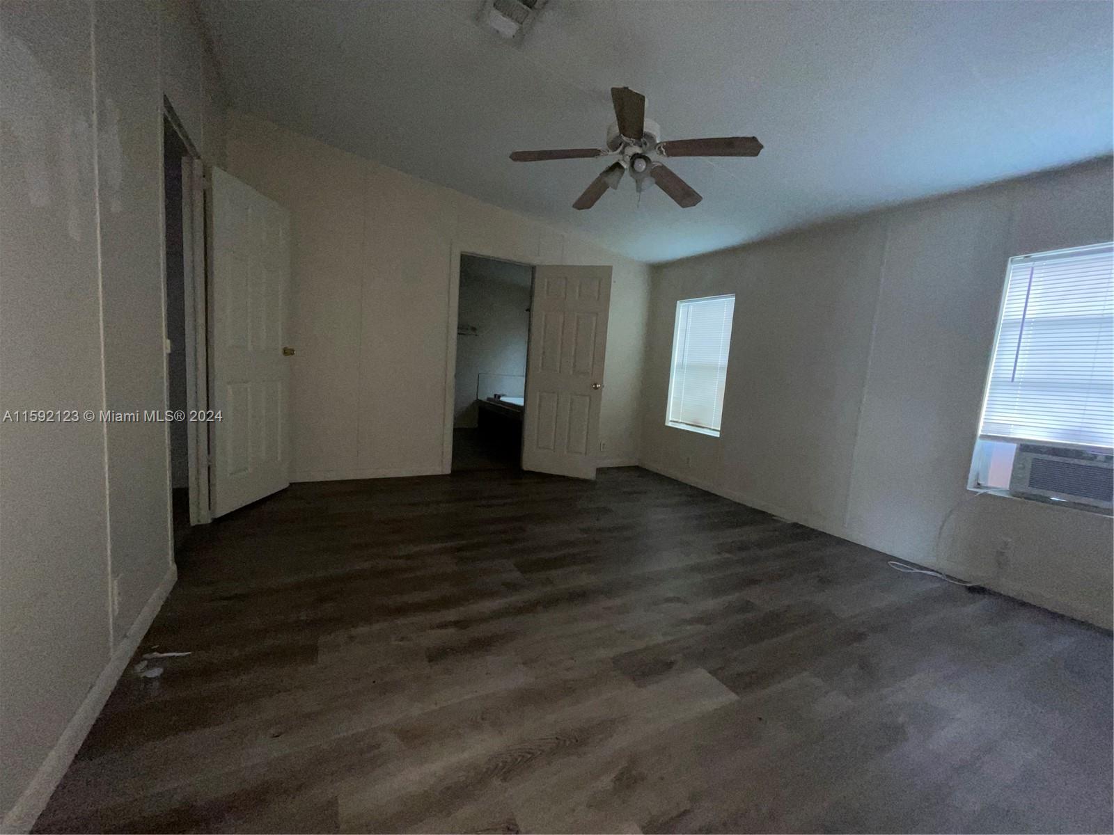 10128 Marlin Drive, Unit 1 Boca Raton, FL 33428 - Photo 12 of 17 a view of empty room with wooden floor and fan