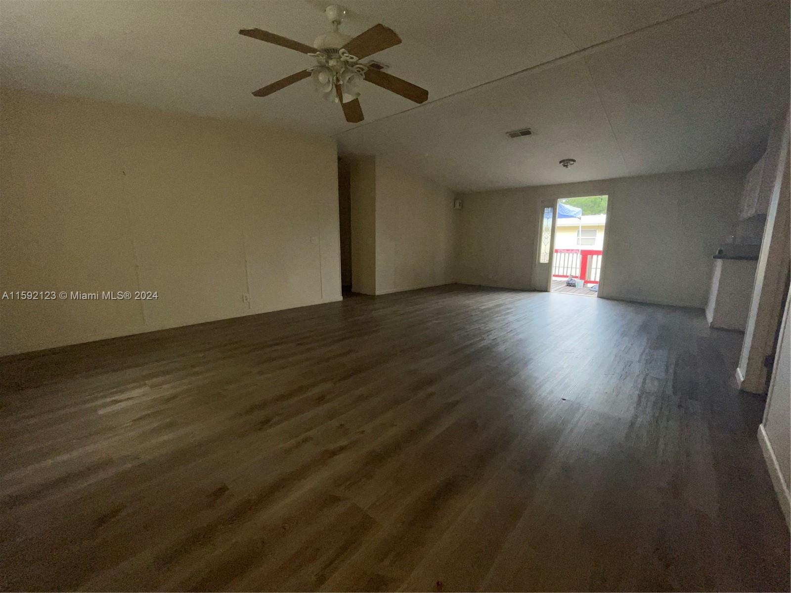 10128 Marlin Drive, Unit 1 Boca Raton, FL 33428 - Photo 13 of 17 an empty room with wooden floor and windows