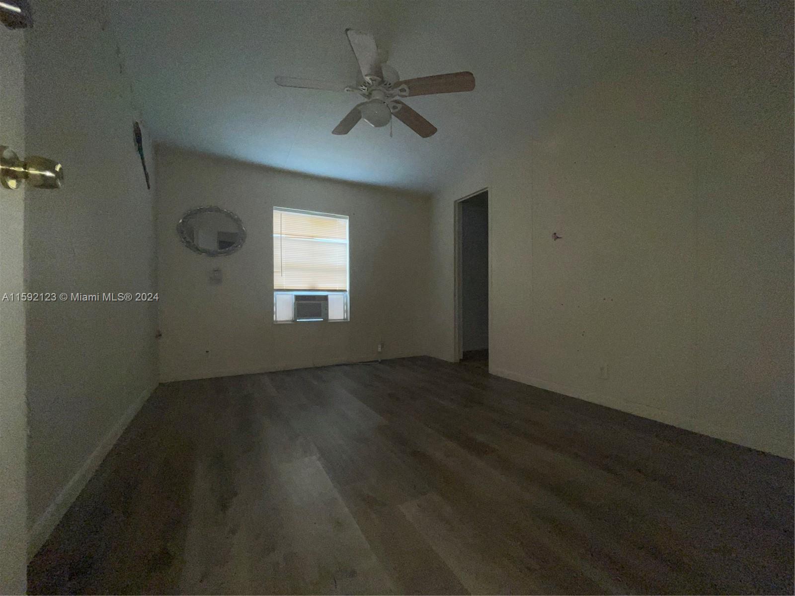10128 Marlin Drive, Unit 1 Boca Raton, FL 33428 - Photo 14 of 17 an empty room with wooden floor and windows