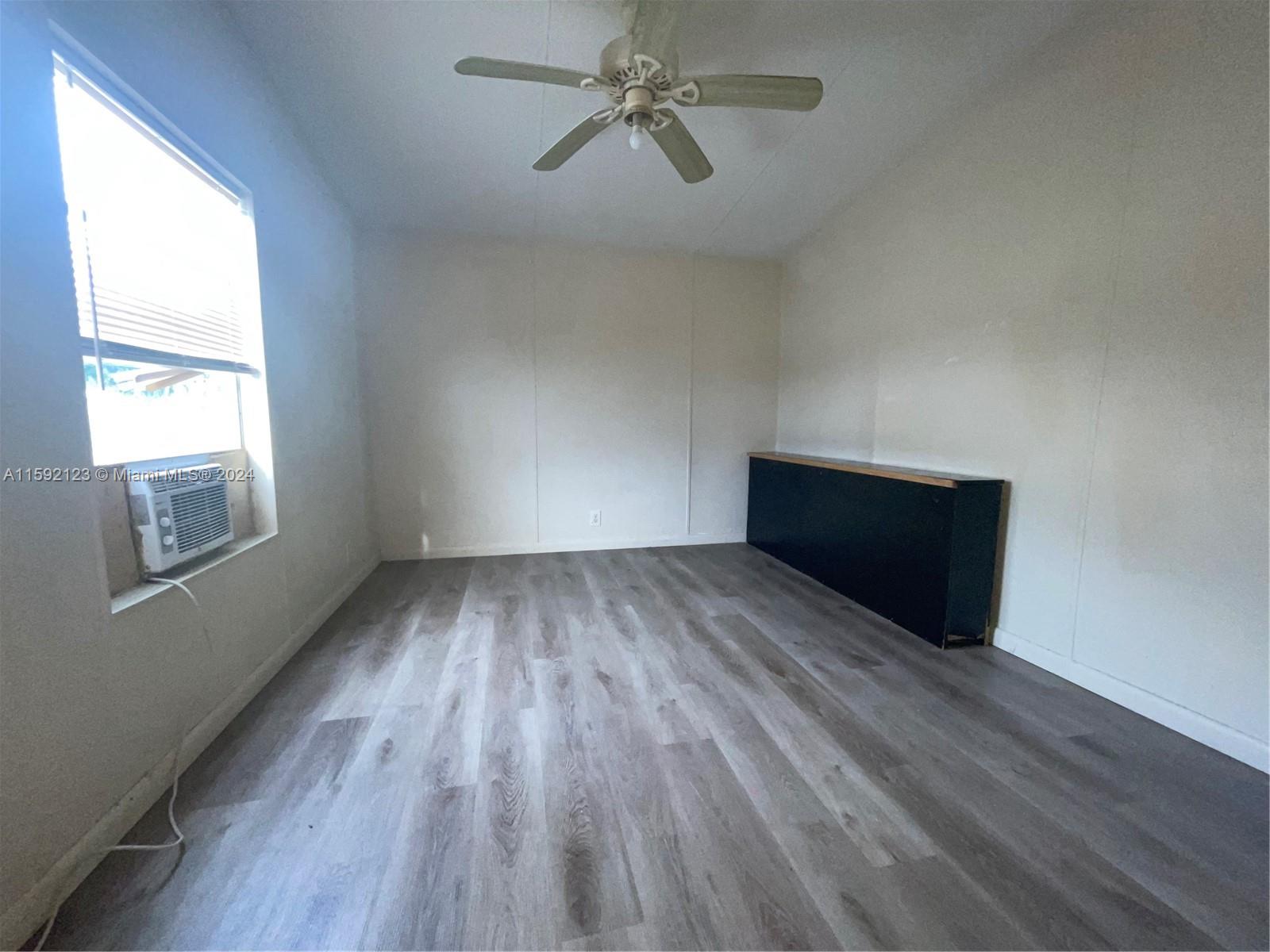 10128 Marlin Drive, Unit 1 Boca Raton, FL 33428 - Photo 15 of 17 a view of empty room with wooden floor and fan