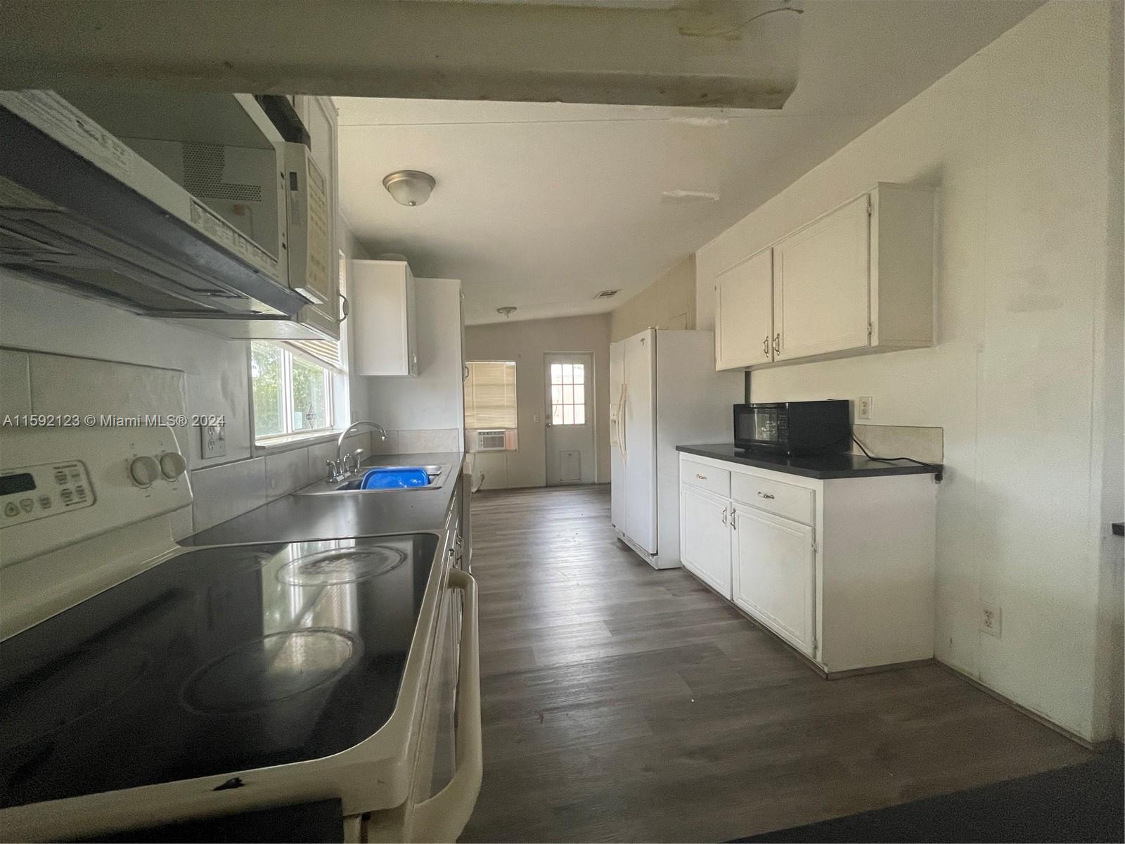 10128 Marlin Drive, Unit 1 Boca Raton, FL 33428 - Photo 6 of 17 a kitchen with stainless steel appliances granite countertop a sink table and chairs