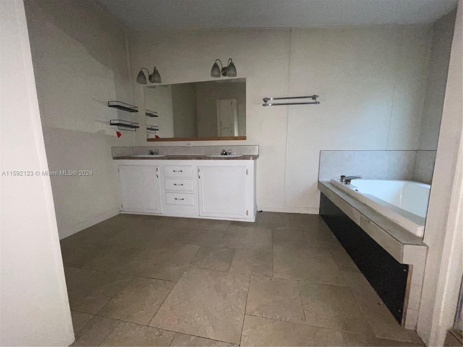 10128 Marlin Drive, Unit 1 Boca Raton, FL 33428 - Photo 9 of 17 a kitchen with a stove and white cabinets