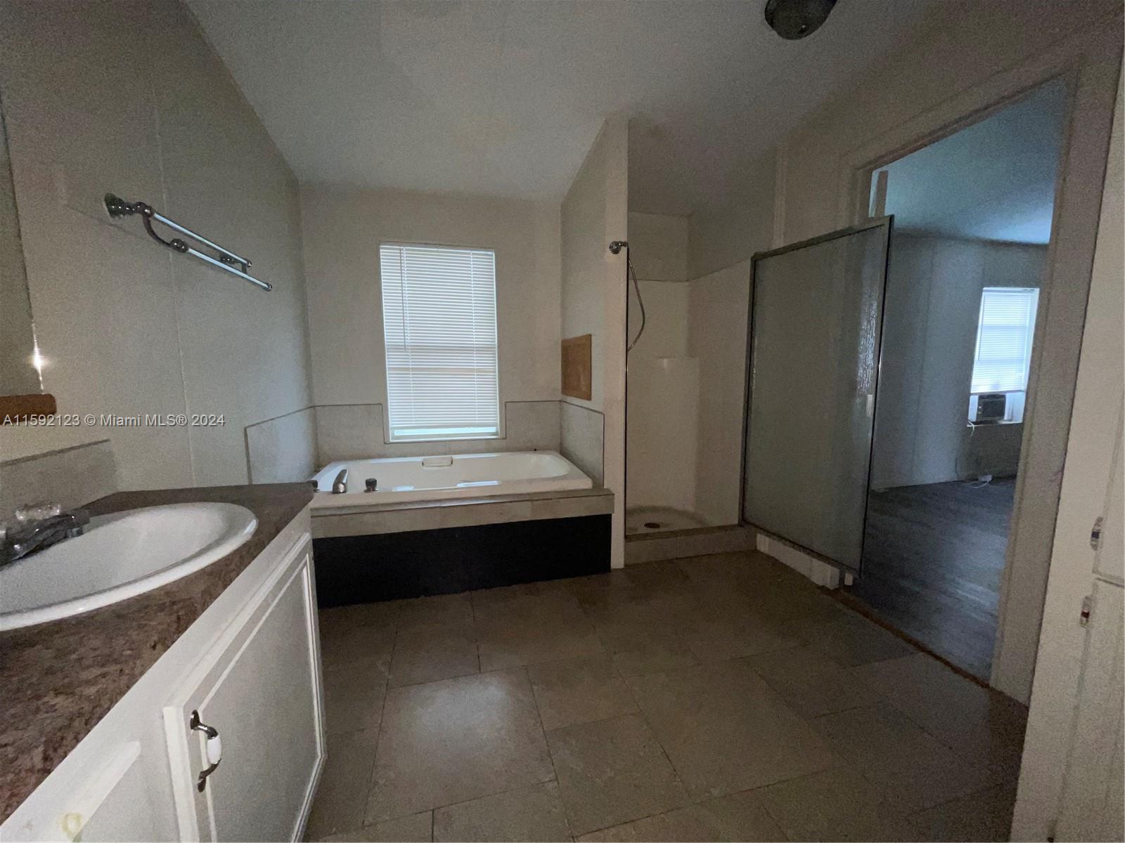 10128 Marlin Drive, Unit 1 Boca Raton, FL 33428 - Photo 10 of 17 a bathroom with a granite countertop sink and a mirror