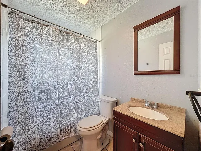 a bathroom with a granite countertop sink toilet and a mirror