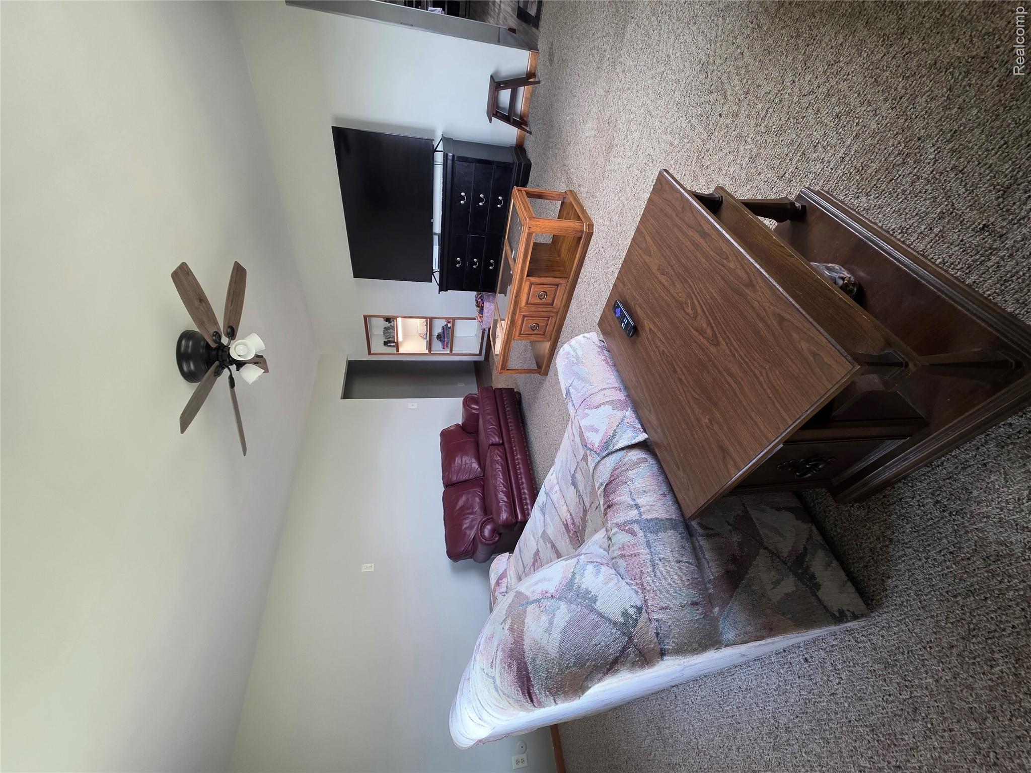 5847 F Road Bark River, MI 49807 - Photo 10 of 25 Living area with carpet flooring and a ceiling fan