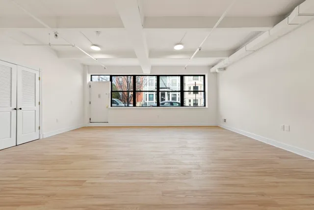 a view of an empty room with a window and front door