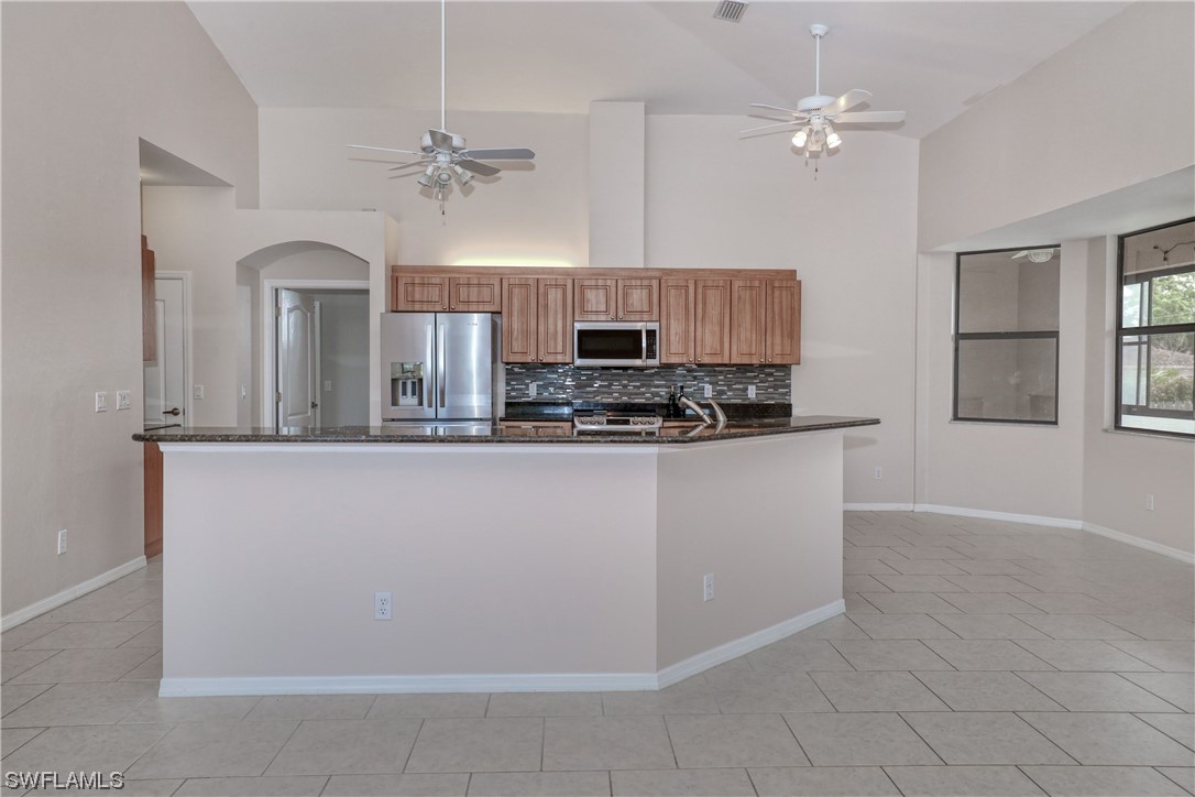 17501 Homewood Road Fort Myers, FL 33967 - Photo 15 of 50 a kitchen with kitchen island granite countertop a refrigerator a stove a oven and a sink with granite countertops