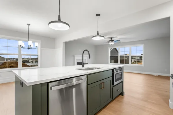 a kitchen with center island a sink and a wooden floor