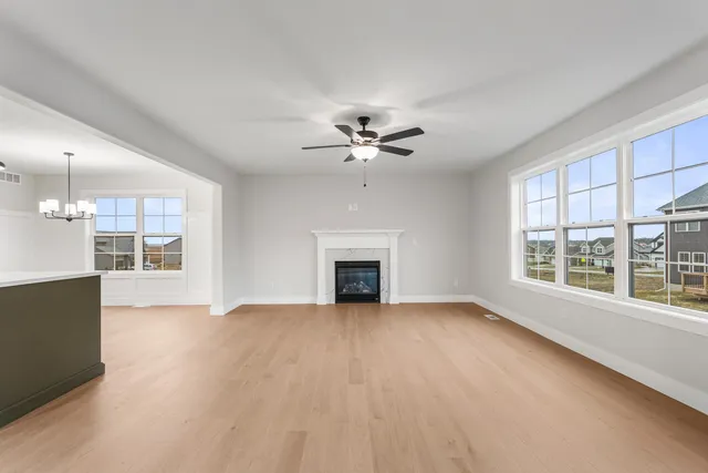 a view of an empty room with a fireplace and a window