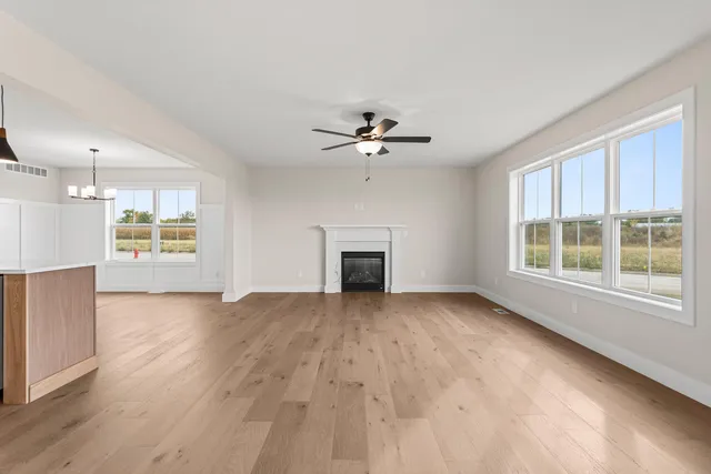 a view of an empty room with a fireplace and a window