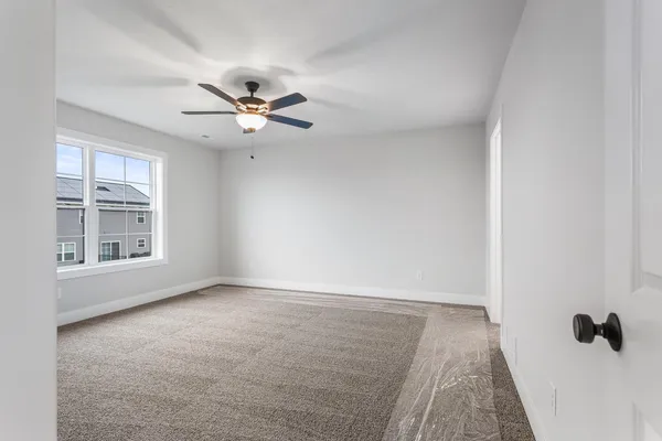 an empty room with windows and ceiling fan view