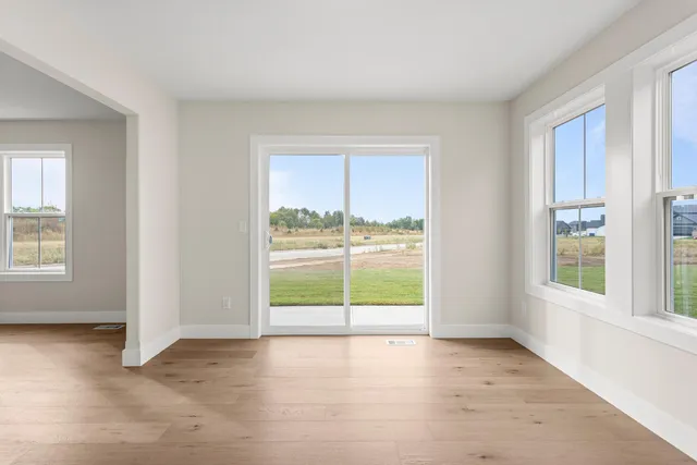 an empty room with windows and view of an empty room
