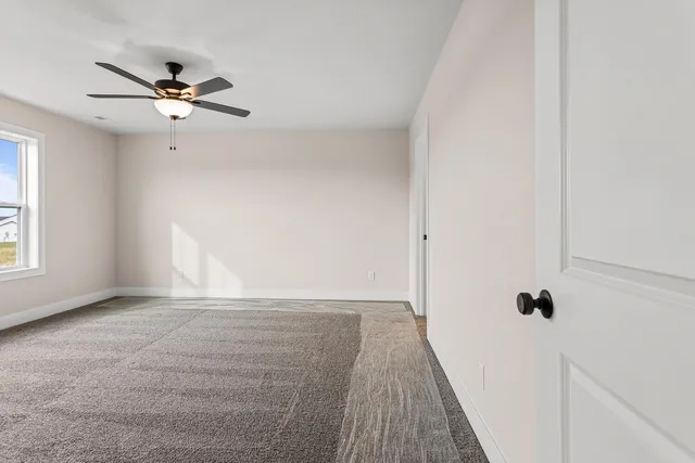 a view of a livingroom with a ceiling fan and wooden floor