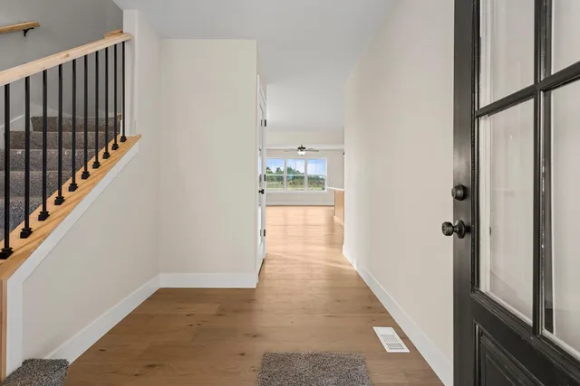 a view of a hallway with wooden floor and staircase