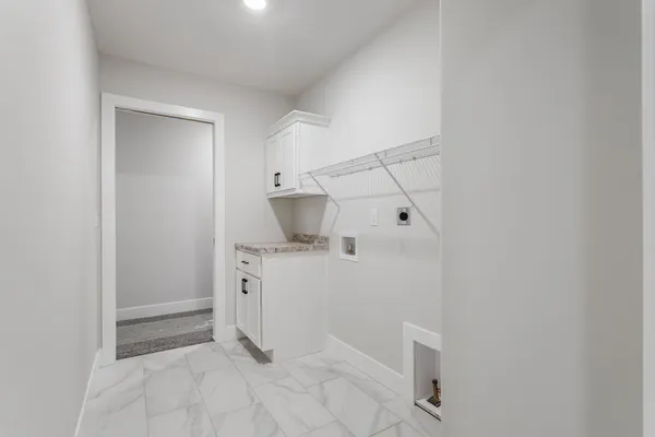 a bathroom with a granite countertop sink and white cabinets