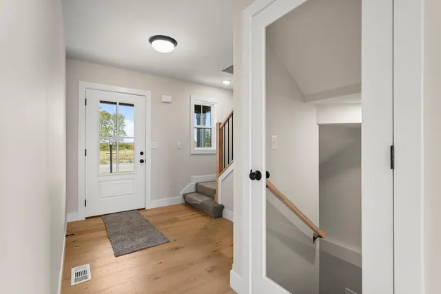 a view of a bedroom with wooden floor and a hallway