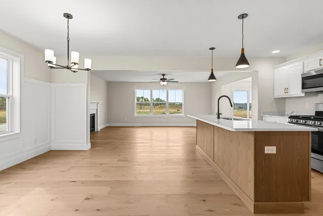 a view of a kitchen with a sink wooden floor a refrigerator and window