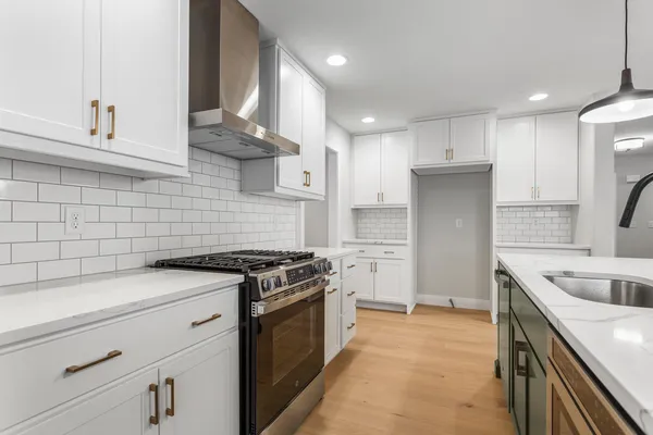 a kitchen with stainless steel appliances granite countertop a sink a stove and a refrigerator