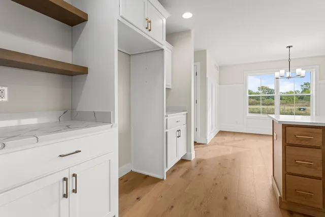 a view of hallway with wooden floor and cabinet