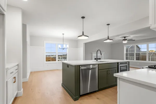 a kitchen with stainless steel appliances granite countertop a sink a stove and a wooden floors