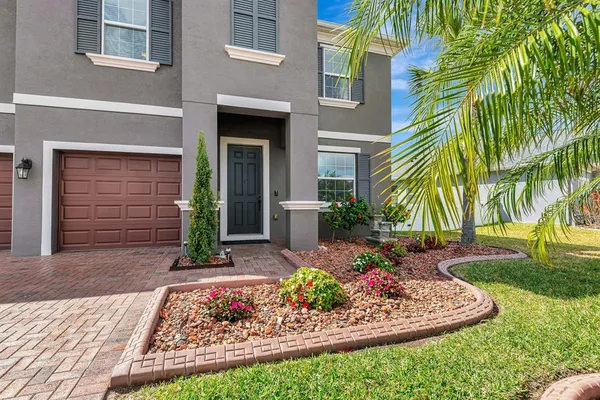 a view of a house with brick walls and a small yard