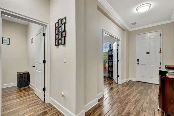 a kitchen with stainless steel appliances kitchen island granite countertop a stove a sink a refrigerator and white cabinets with wooden floor