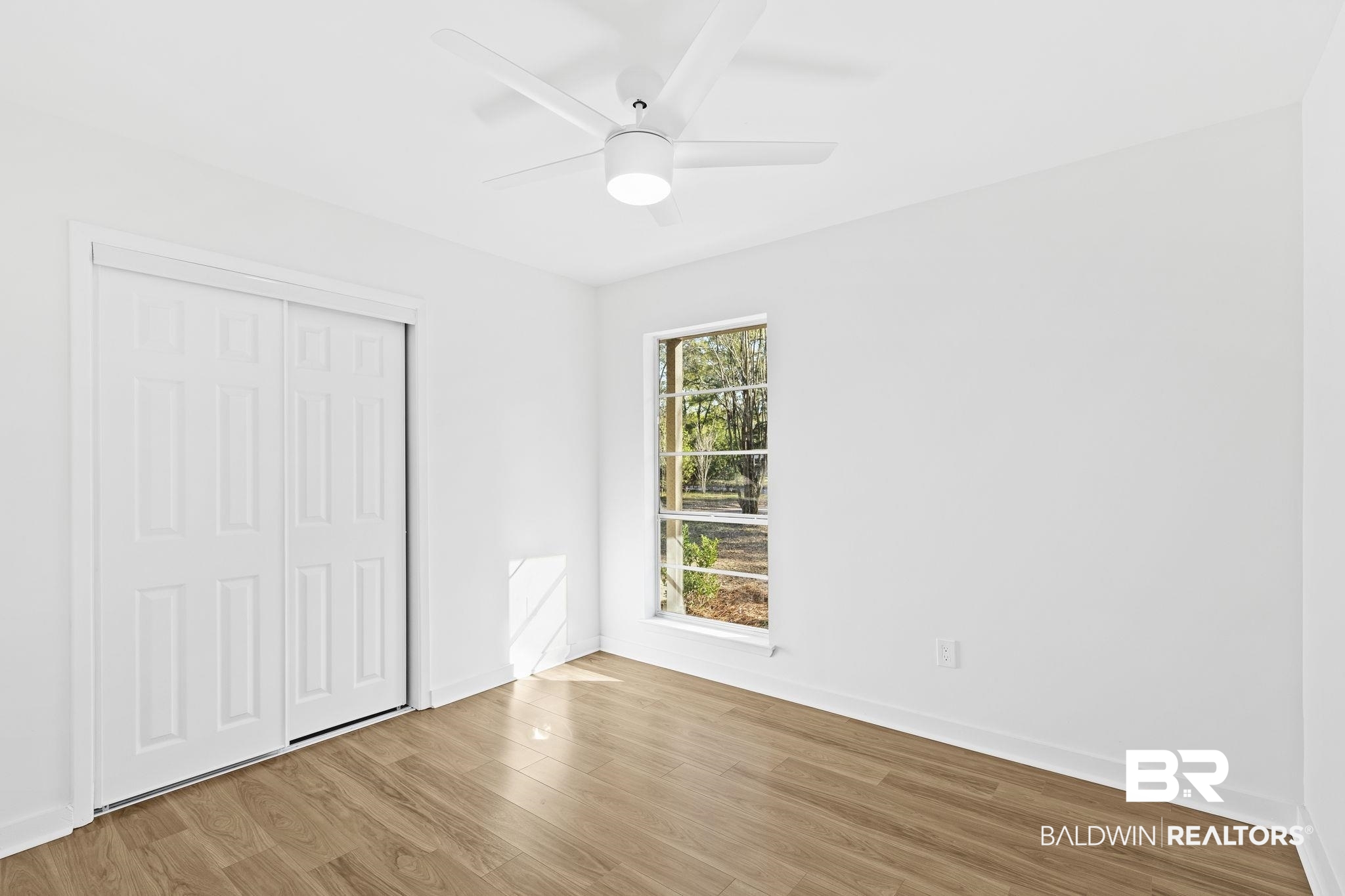5398 Quail Run North Theodore, AL 36582 - Photo 29 of 46 Unfurnished bedroom featuring ceiling fan, a closet, light wood-type flooring, and multiple windows