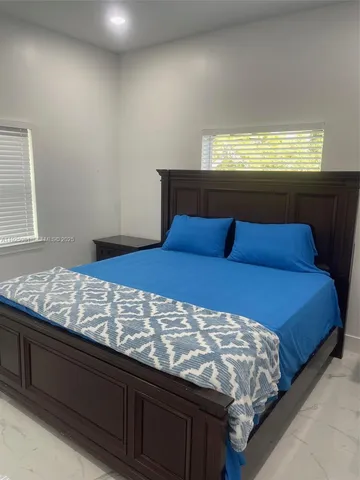 a bed sitting in a bedroom next to a lamp