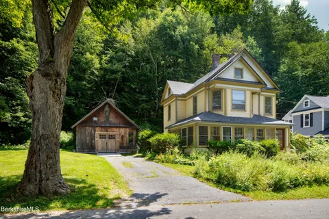 a front view of a house with a yard and trees