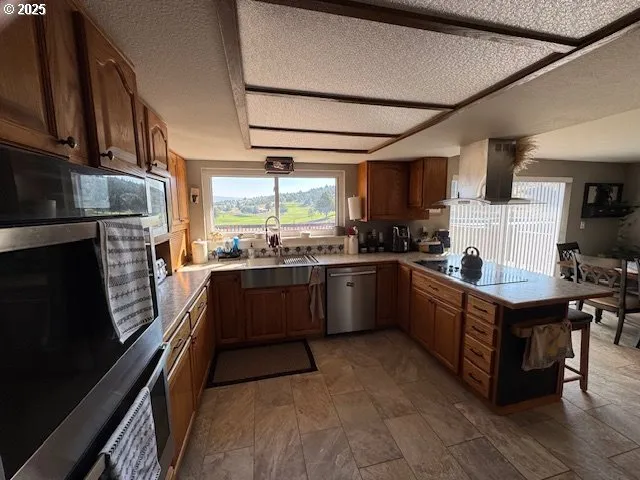 a kitchen with stainless steel appliances a sink cabinets and a window