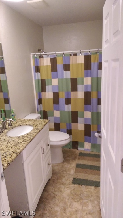 17501 Butler Road Fort Myers, FL 33967 - Photo 12 of 20 a bathroom with a granite countertop toilet a sink and a mirror