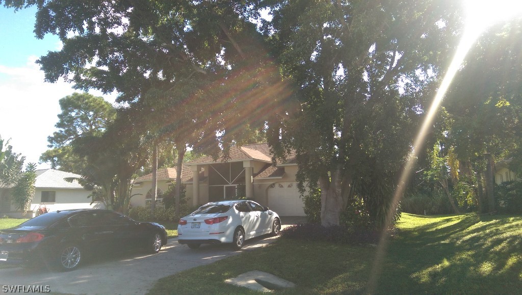 17501 Butler Road Fort Myers, FL 33967 - Photo 4 of 20 a wooden bench sitting in middle of a yard