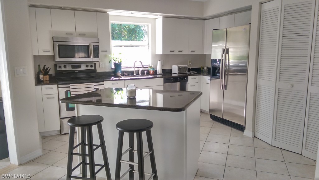 17501 Butler Road Fort Myers, FL 33967 - Photo 9 of 20 a kitchen with stainless steel appliances granite countertop a stove a refrigerator a sink a microwave and a refrigerator