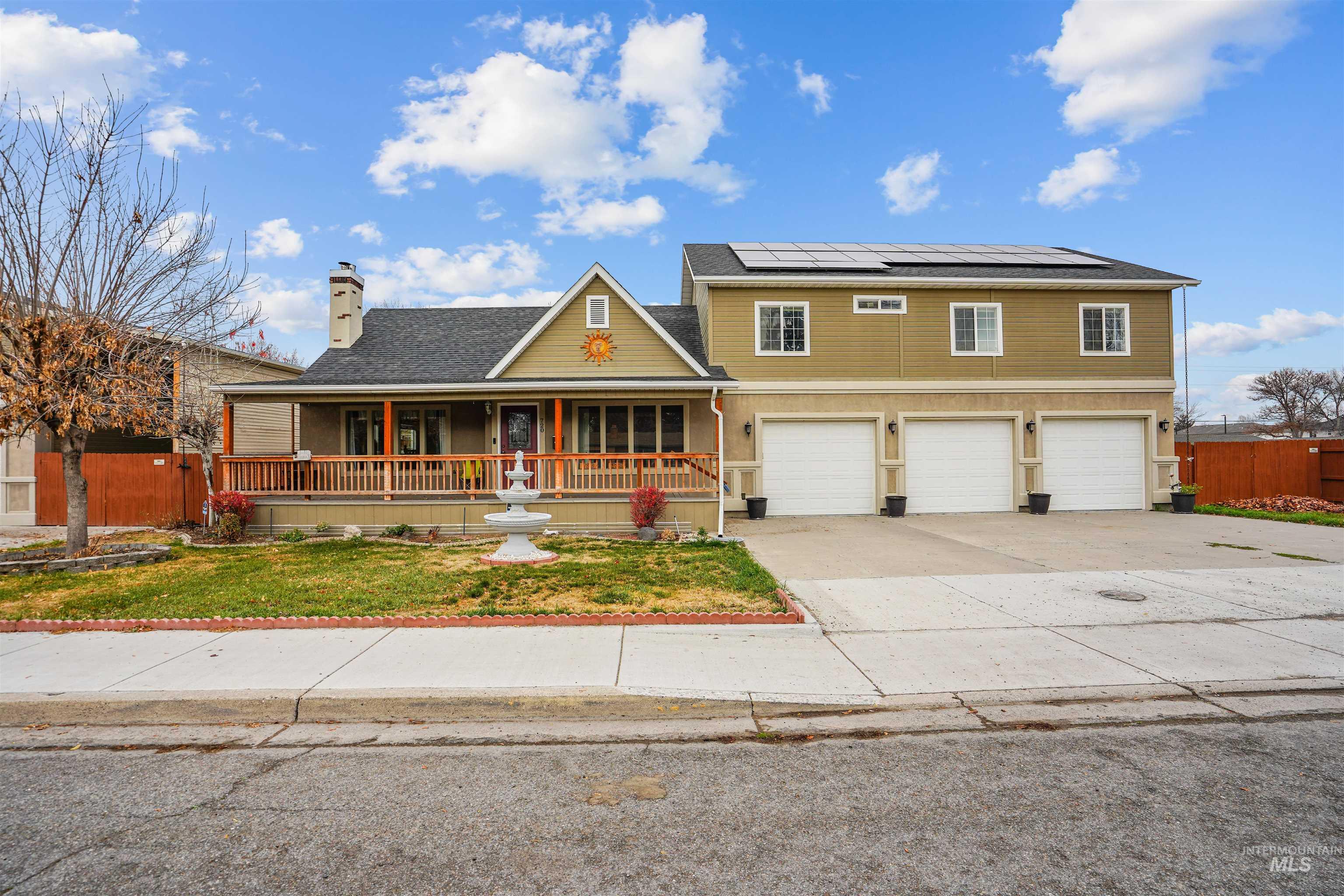 720 East Main Street Jerome, ID 83338 - Photo 36 of 50 View of front of home with covered porch, driveway, roof mounted solar panels, a garage, and a chimney