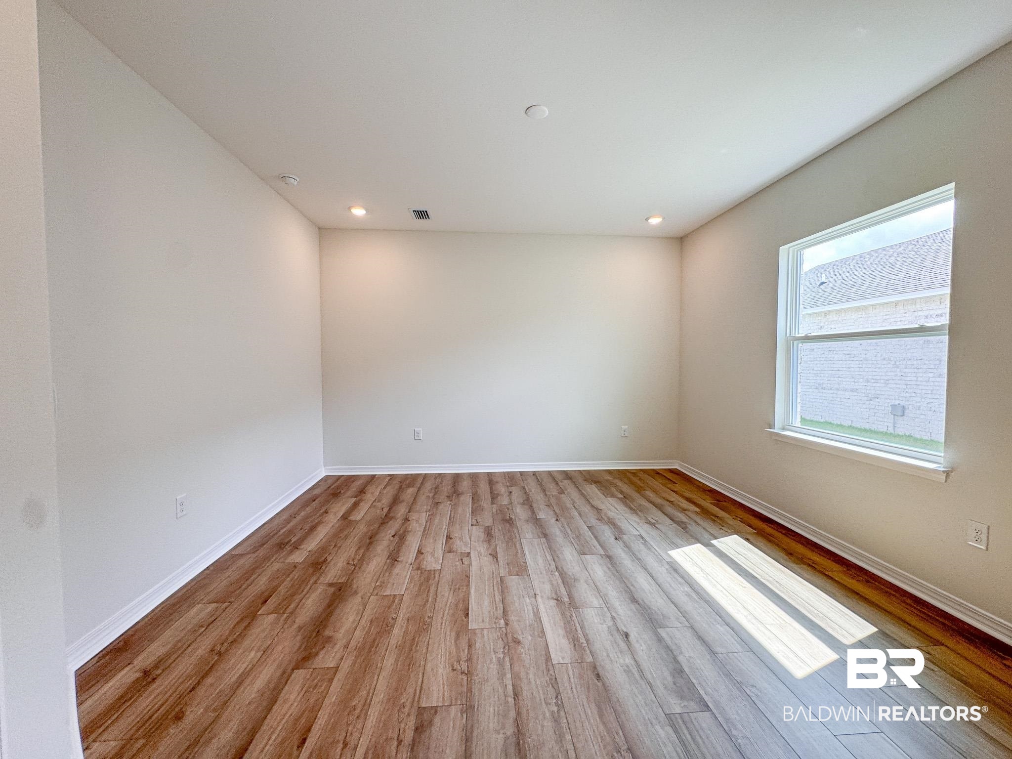 18151 Kent Circle Foley, AL 36535 - Photo 20 of 25 Spacious room featuring wood-finish flooring, recessed lighting, and a prominent window with white trim