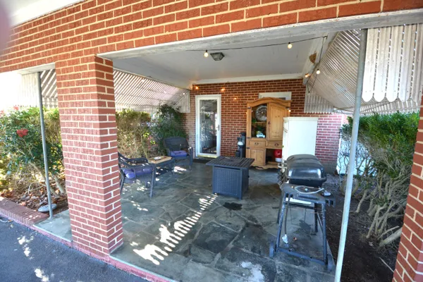 a view of a brick house next to a yard