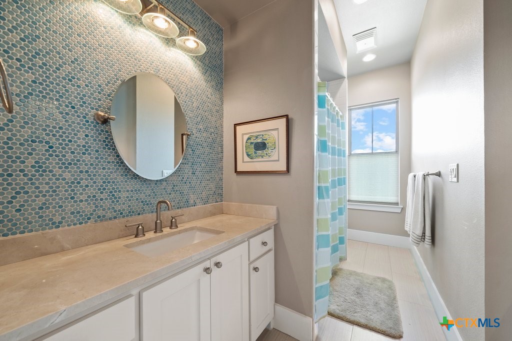 1165 Turtle Trail New Braunfels, TX 78130 - Photo 23 of 48 a en suite bathroom with a double vanity sink and a mirror