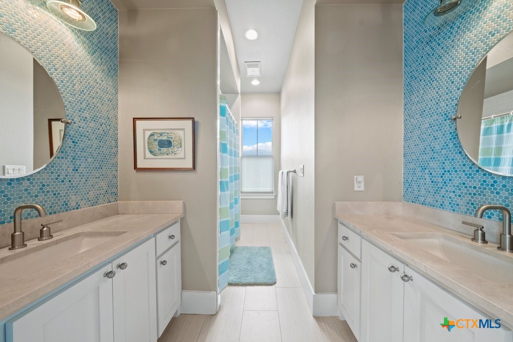 1165 Turtle Trail New Braunfels, TX 78130 - Photo 25 of 48 a bathroom with a sink and a mirror