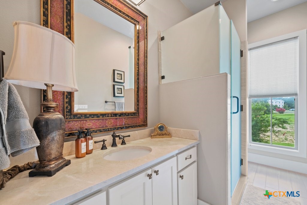 1165 Turtle Trail New Braunfels, TX 78130 - Photo 32 of 48 a bathroom with a granite countertop sink and a mirror