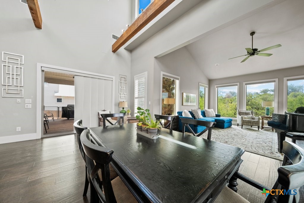 1165 Turtle Trail New Braunfels, TX 78130 - Photo 9 of 48 a view of a dining room and livingroom with furniture wooden floor a rug a potted plant a fireplace and a chandelier