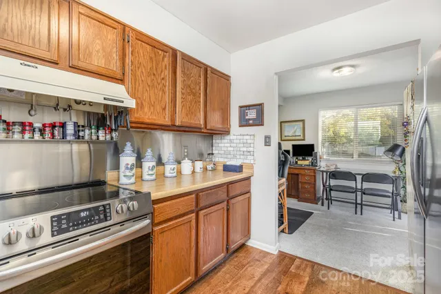 a kitchen with stainless steel appliances a stove a sink and cabinets