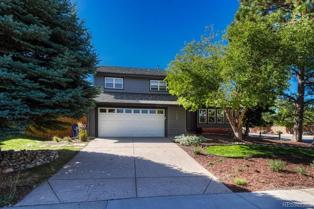 a front view of a house with a yard garage and outdoor seating