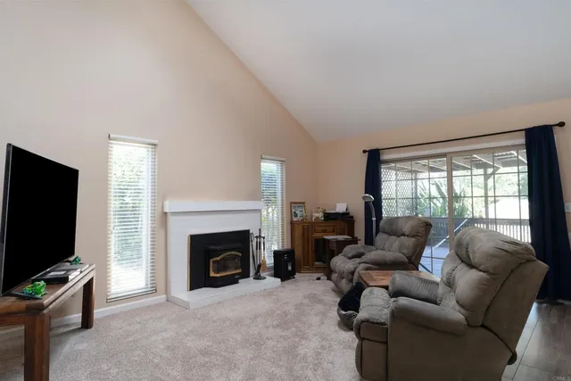 a backyard of a house with wooden fence and a lawn chairs