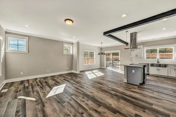 a view of a bedroom with wooden floor and windows
