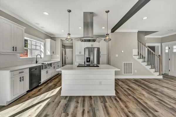 a kitchen with stainless steel appliances a refrigerator and a stove top oven