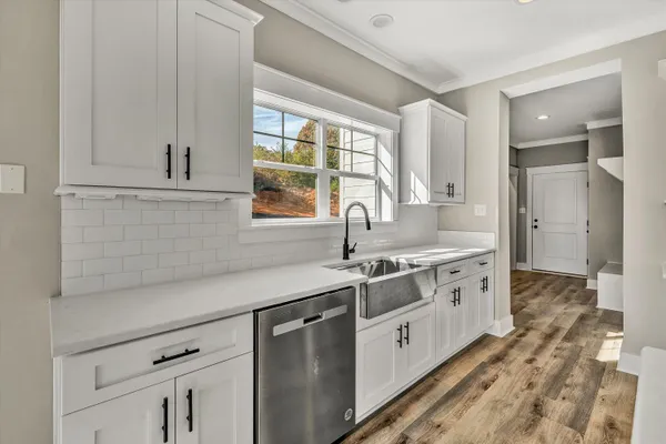 a kitchen that has a stove and a wooden floor